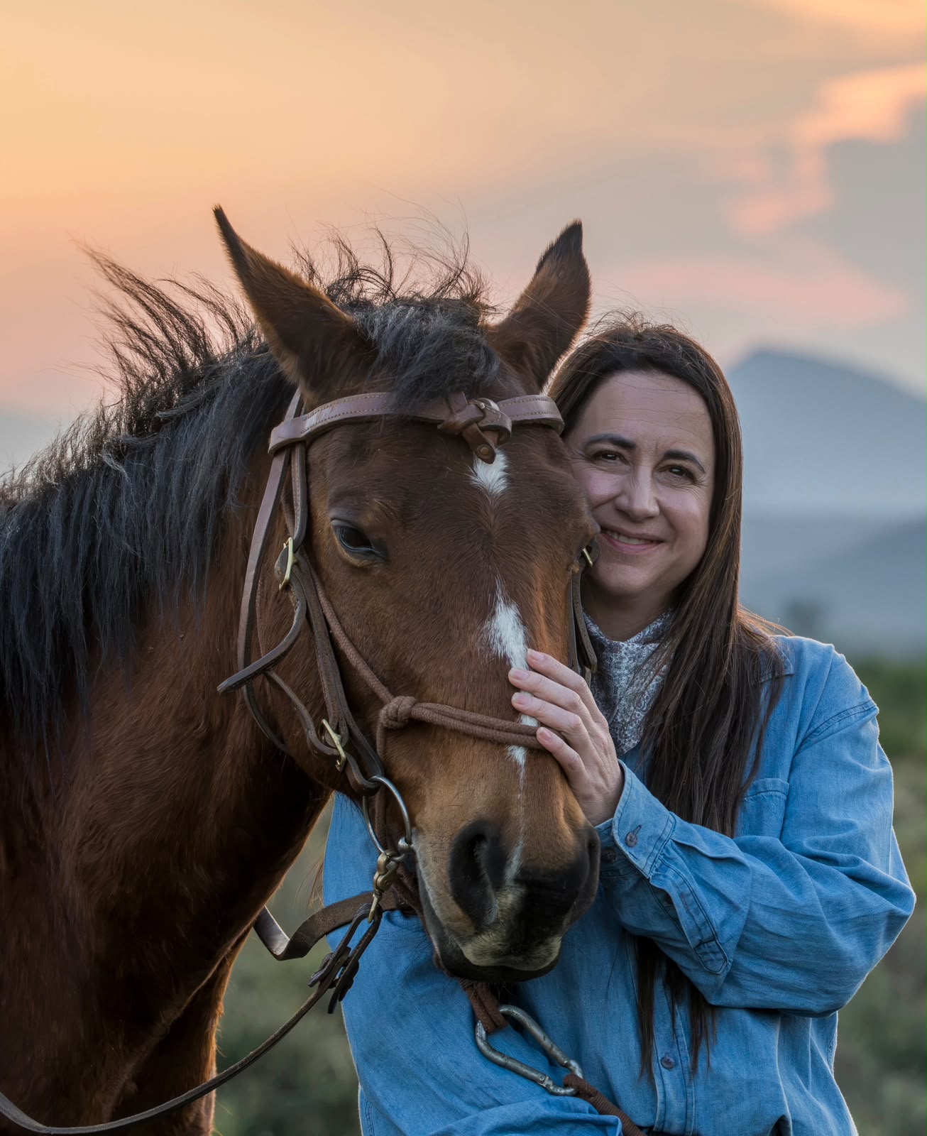 Sasja van der Merwe with a bay horse at sunset